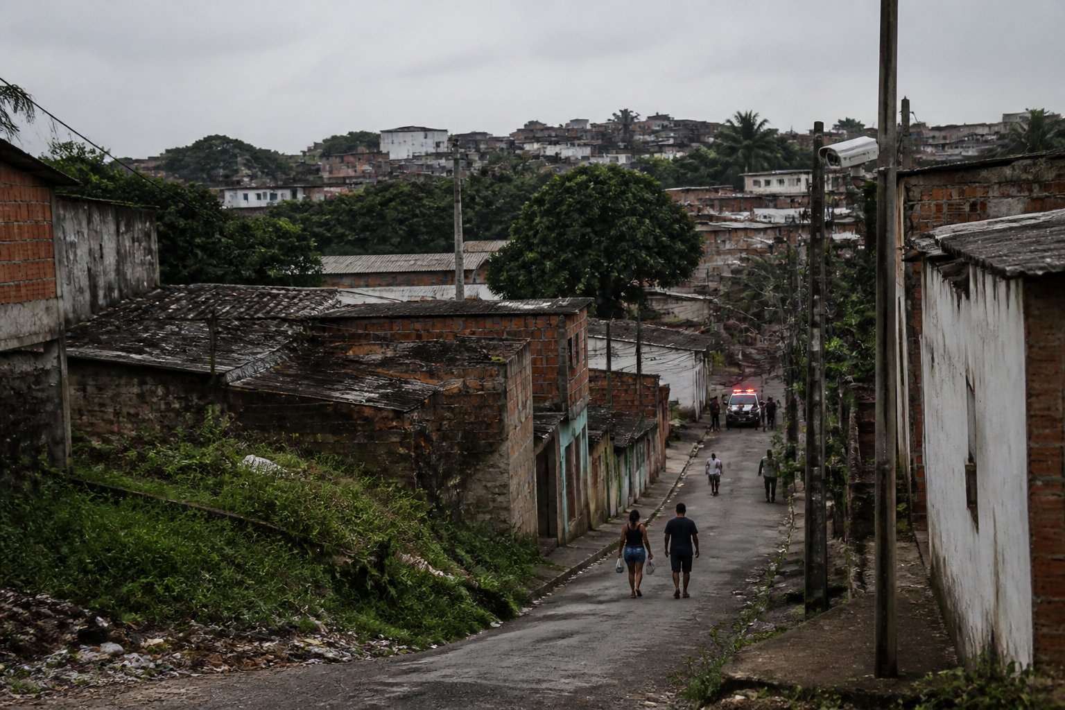 Vista de um bairro residencial modesto em João Pessoa com casas simples, ruas estreitas e pouca iluminação, transmitindo sensação de insegurança.